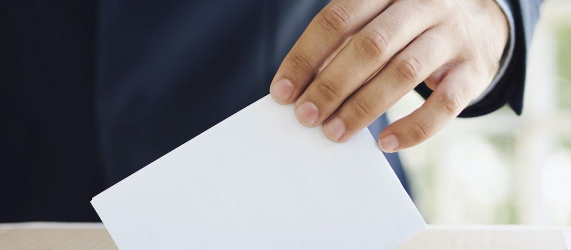 man-putting-empty-ballot-election-box (1)-min